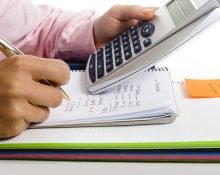 Calculating monthly costs Man with Calculator and the cost of Living